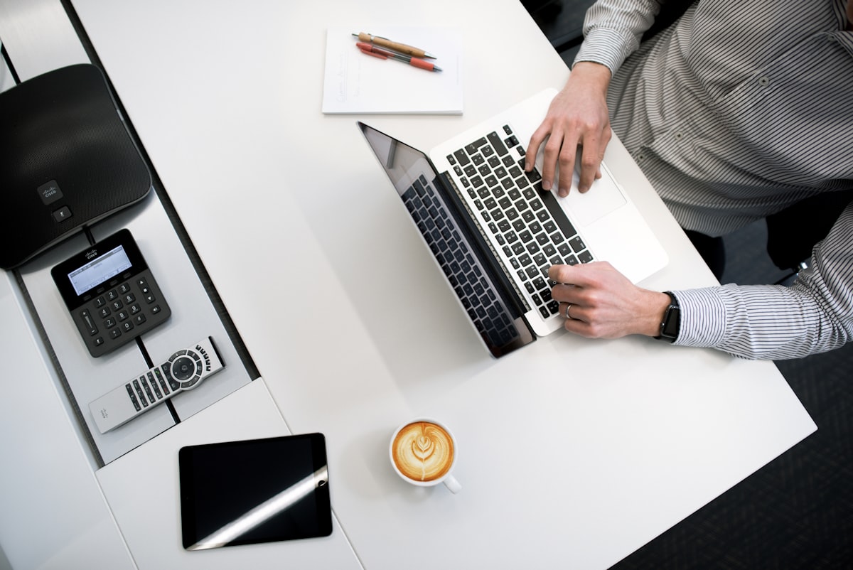 Loan documents, calculator, and laptop on a desk